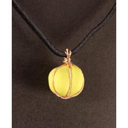 Polymer cushion bead in green with copper, on leather 